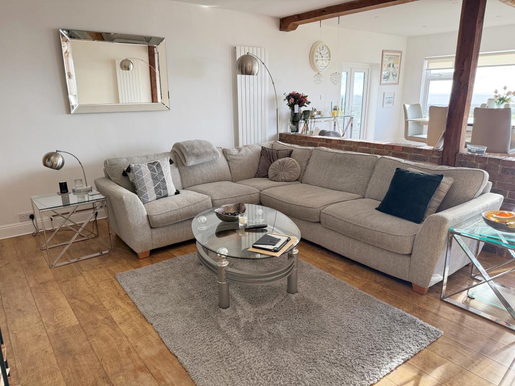 Lot: 62 - DETACHED HOUSE WITH SEA VIEWS PLUS ADJOINING LAND WITH PLANNING - Raised dining area with views and doors to garden